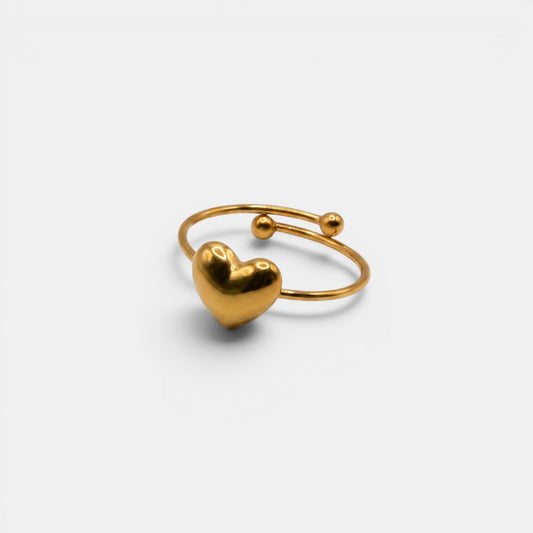 Schlichter Cleo Heart Ring aus Gold mit einem einzelnen glatten Goldherz auf hellem Hintergrund.