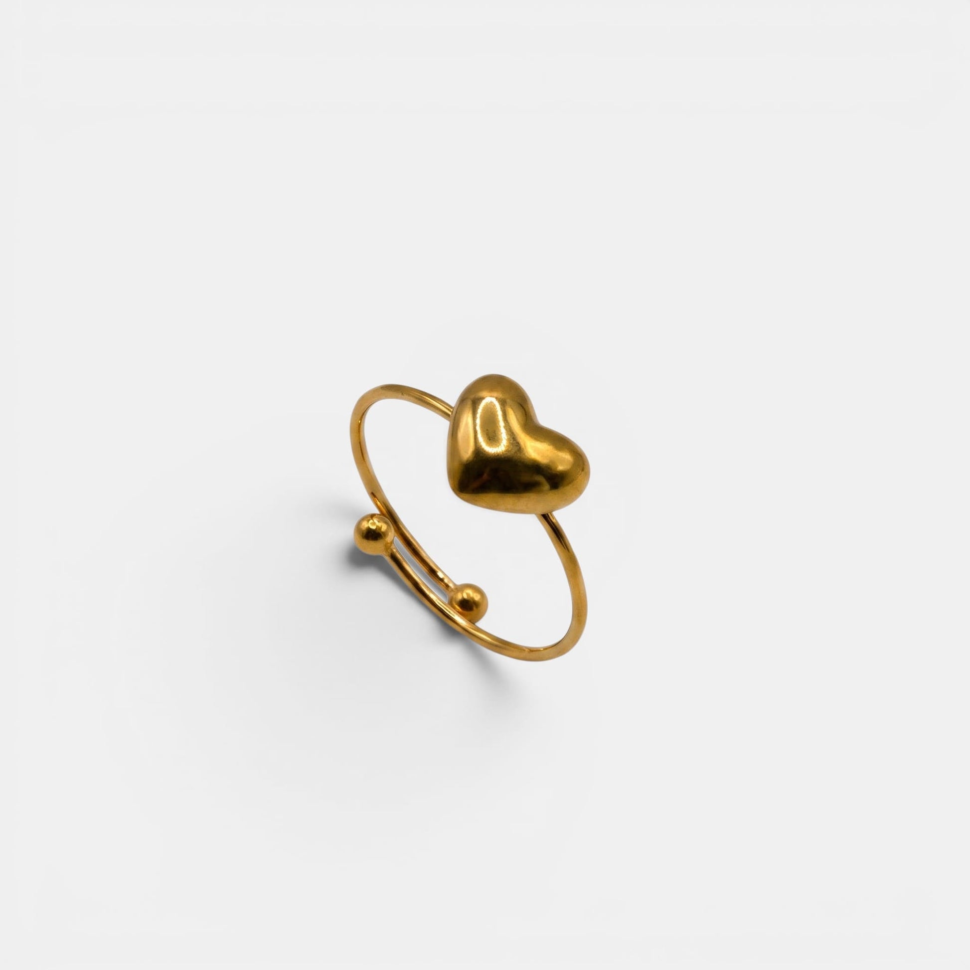 Schlichter Cleo Heart Ring aus Gold mit einem einzelnen glatten Goldherz auf hellem Hintergrund.