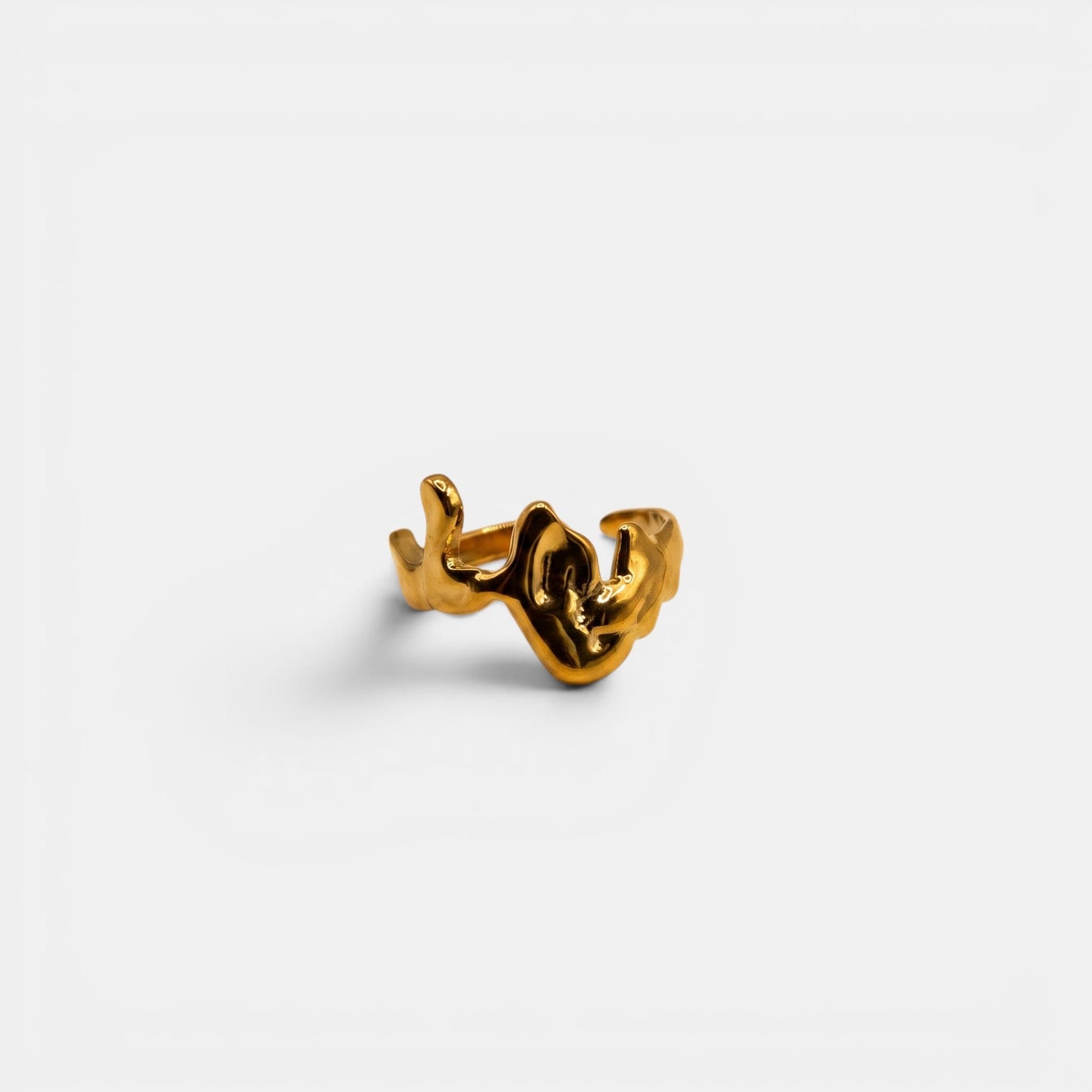 Organischer Cove Ring in geschmolzener "Liquid Gold"-Optik auf einem cleanen Studio-Hintergrund.