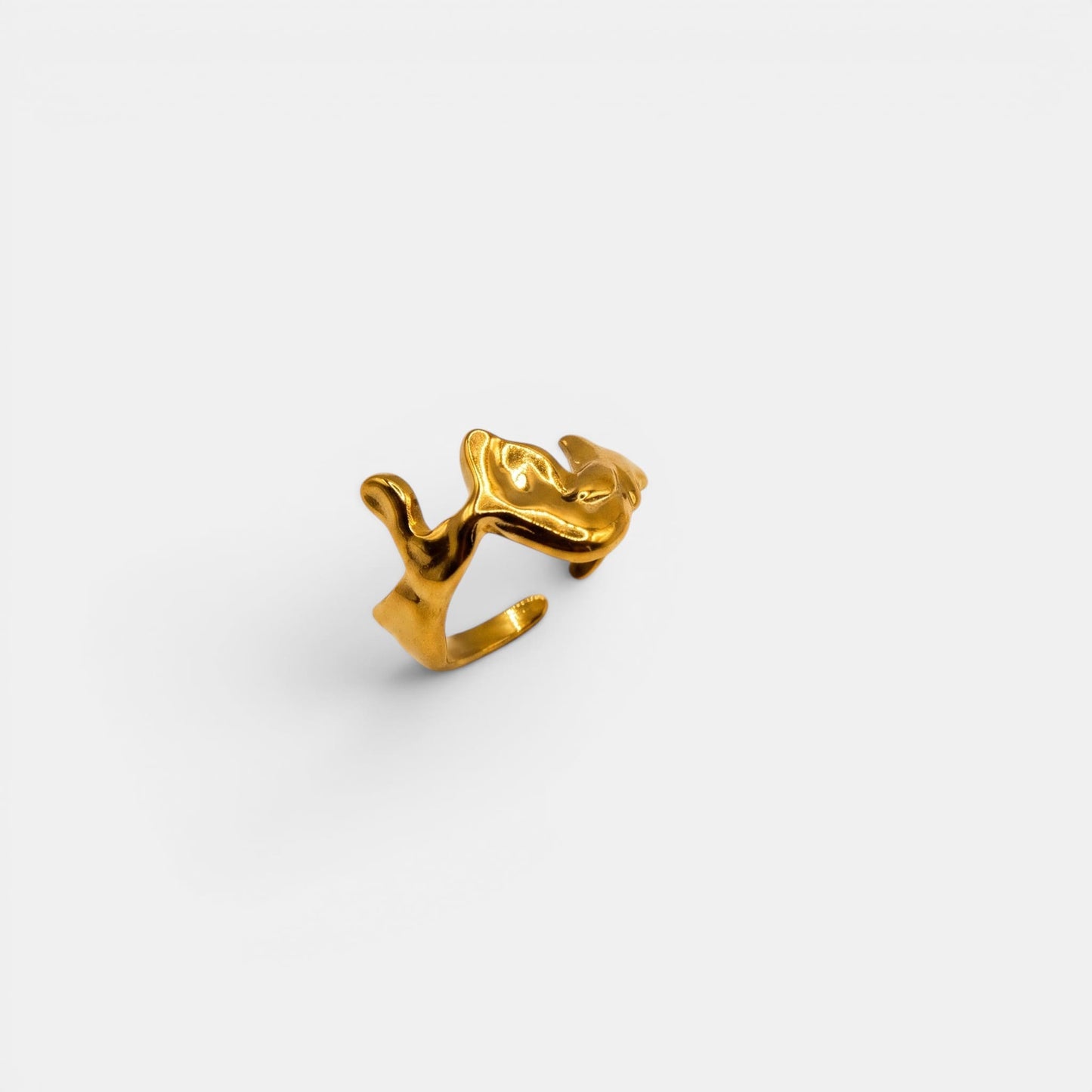 Organischer Cove Ring in geschmolzener "Liquid Gold"-Optik auf einem cleanen Studio-Hintergrund.