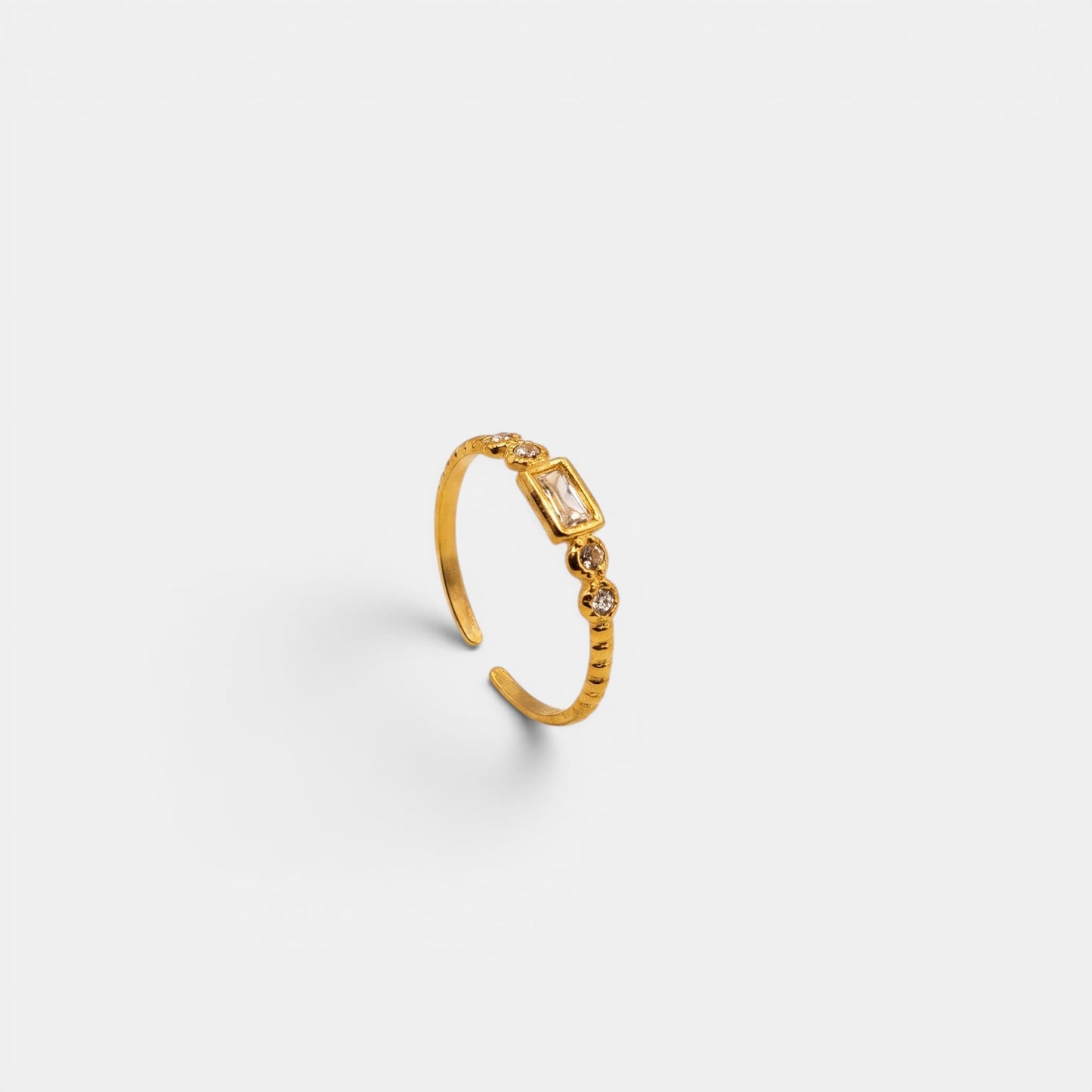 Schmaler Elysian Ring aus Gold mit markantem rechteckigem Kristall im Baguette-Schliff.
