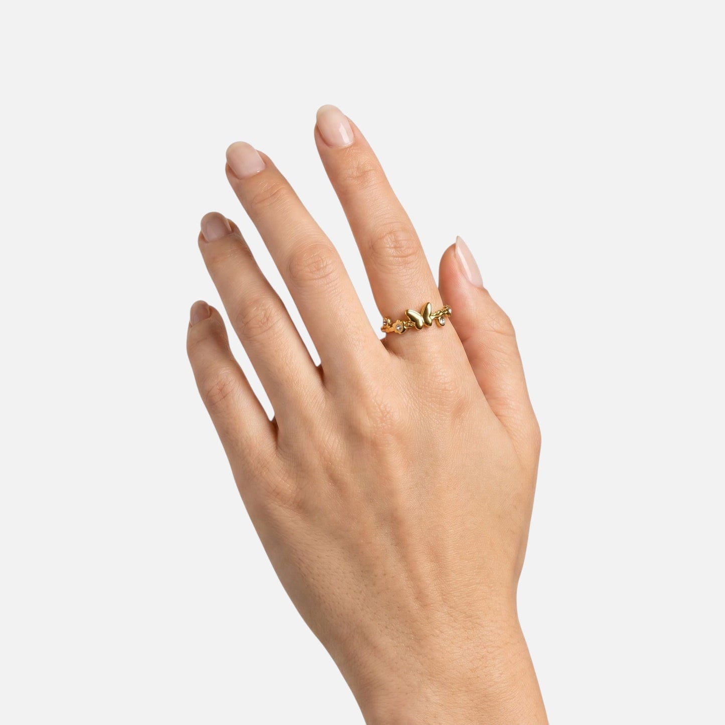 Unbeschwerter Sommer-Look mit dem goldenen Mariposa Schmetterlingsring getragen an einer Frauenhand.