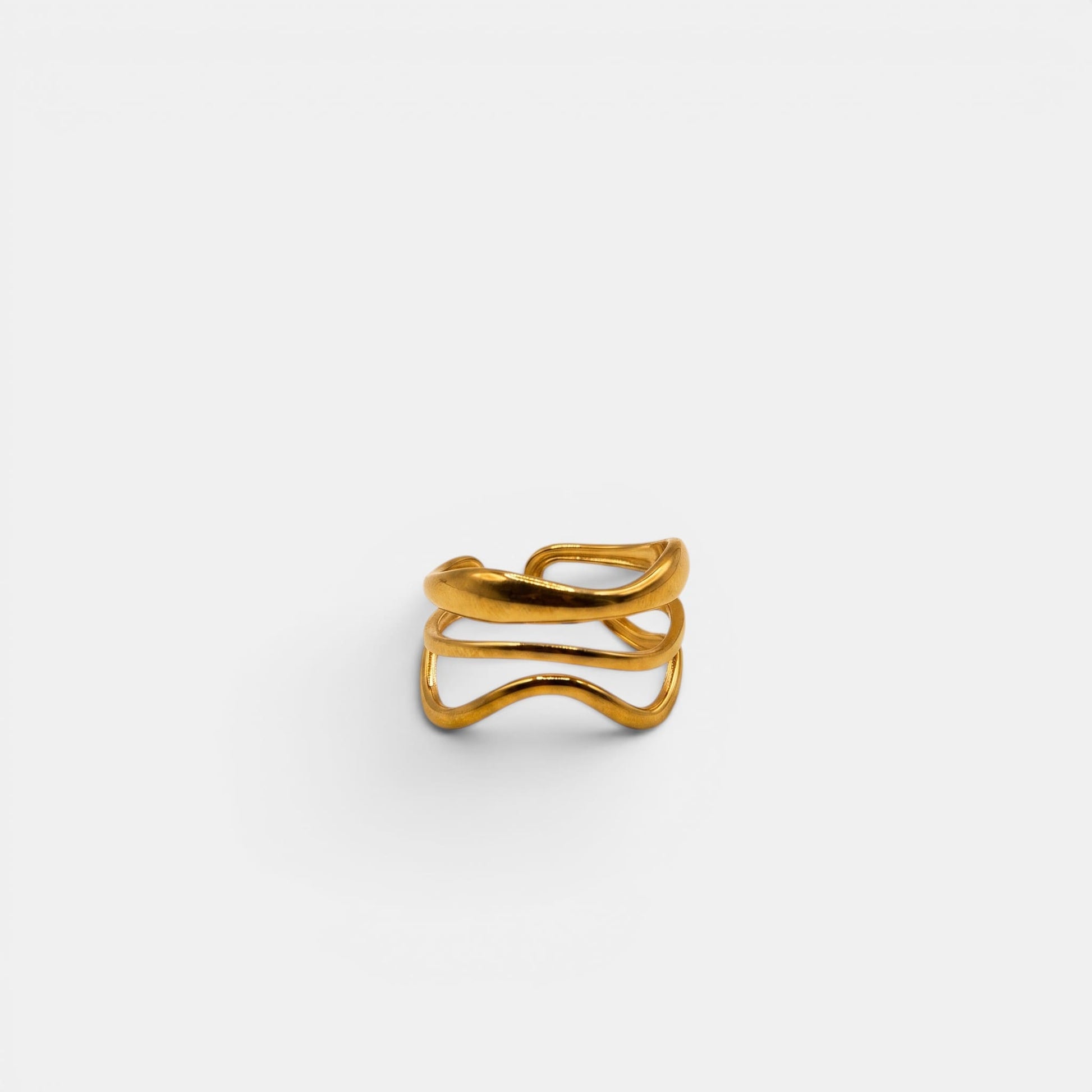 Goldener Nalu Ring mit einem klassischen, glatten dreifachen Wellenmuster auf cremefarbenem Hintergrund.