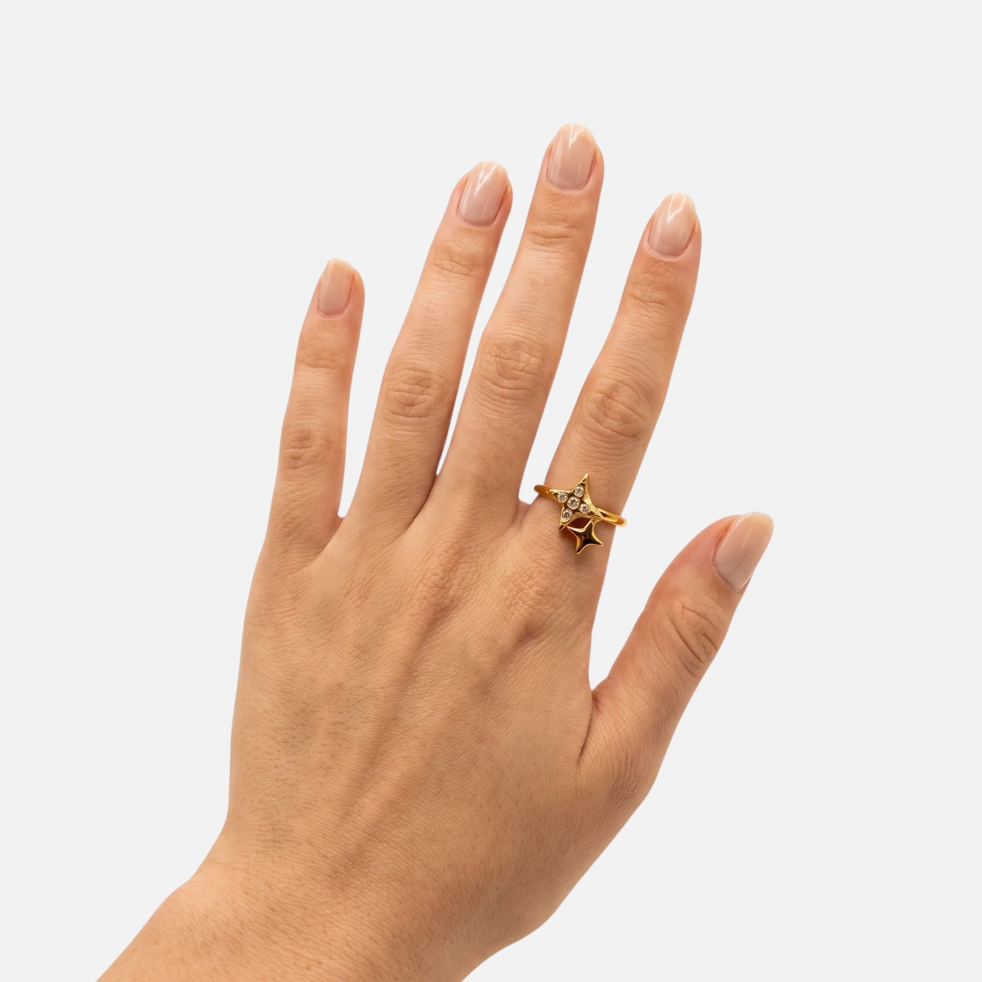 Eine Hand präsentiert den magisch funkelnden Nova Ring im hellen Tageslicht-Studio.