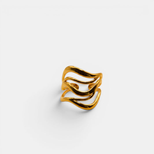 Breiter, mehrreihiger Wave Ring aus Gold mit geschwungener Wellenstruktur auf off-white Hintergrund.