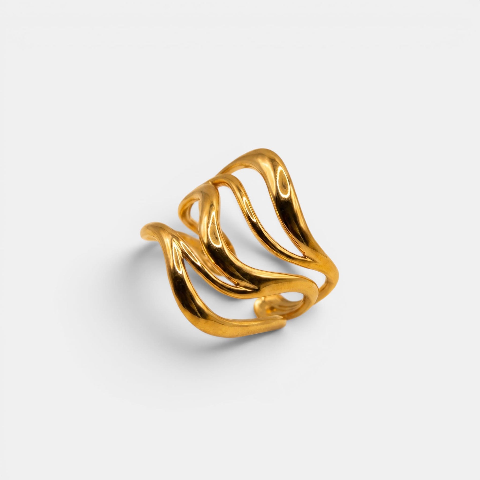 Breiter, mehrreihiger Wave Ring aus Gold mit geschwungener Wellenstruktur auf off-white Hintergrund.